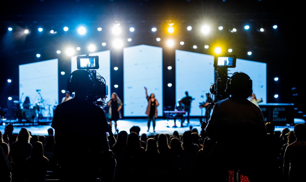 private-party-04 Energetic live concert scene with cameramen filming the vibrant stage performance.